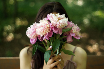 Girl with pink peonies bouquet. Outdoors