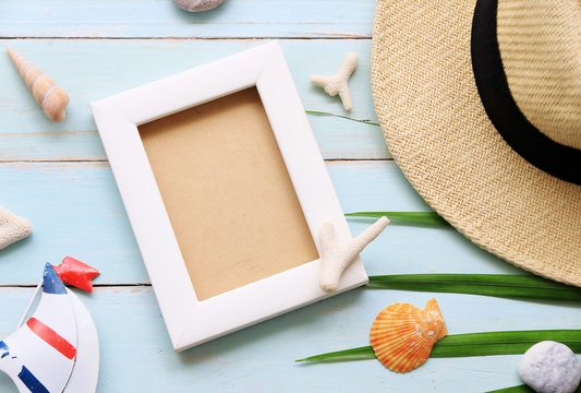 Beach hat and picture frame on wooden table In the summer Asia,copy space,Top view,minimal style