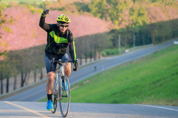 Asian man ride a bicycle on the road with nature background