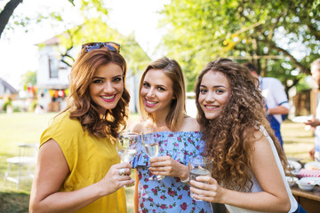 Portrait of three women on a family celebration or a barbecue party outside in the backyard.