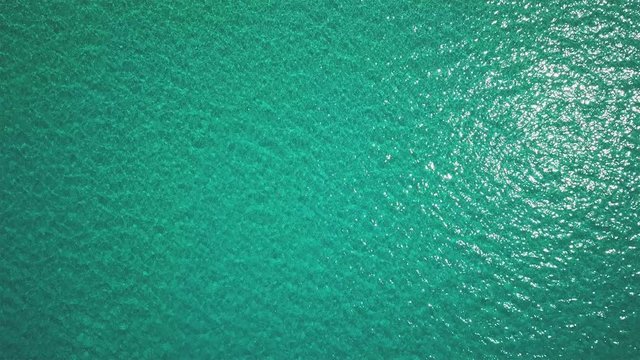 flying over ocean with crystalline water of green color