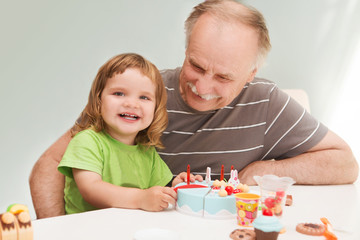 Grandpa and granddaughter are playing with toys at home.
