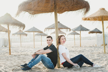 Couple strolling calmly on the warm beach umbrellas
