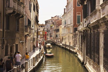 Venice street along canal. Italy. Tourist walking