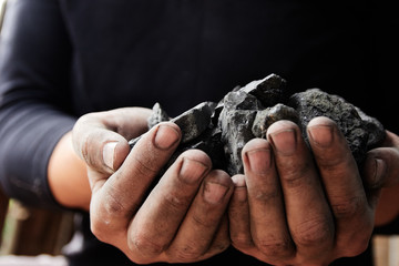 Coal miner in the man hands of coal background. Coal mining or energy source, environment protection. Industrial coals. Volcanic rock.