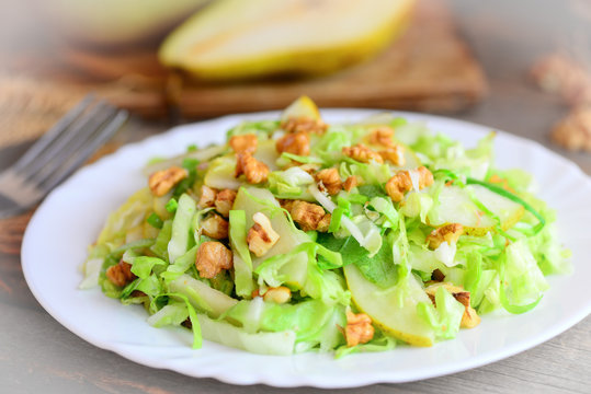 Homemade cabbage slaw with pear and walnuts. Easy pear and cabbage slaw on a plate. Food highest in vitamins. Closeup