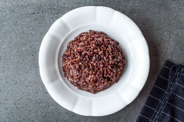 Cooked Black Rice in white Plate with Chopsticks.