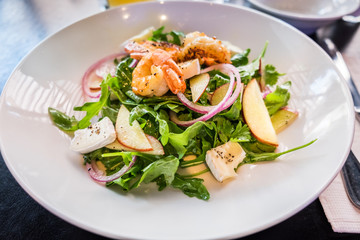 Starter with shrimps, brie, fresh salad leaves and vegetables