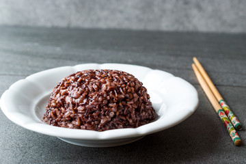 Cooked Black Rice in white Plate with Chopsticks.