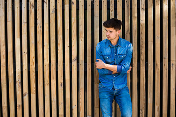 cool guy in jeans outfit on wooden background