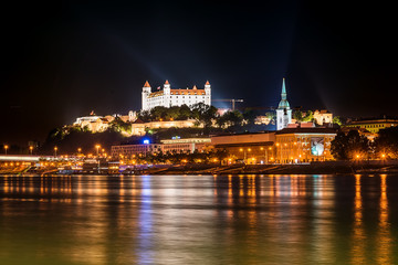 Fototapeta na wymiar Bratislava, Slovakia May 23, 2018: Bratislava at night, with the city lights reflected in the Danube river. On the top hill stands the Bratislava Castle built in the 9th century.