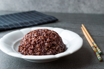 Cooked Black Rice in white Plate with Chopsticks.