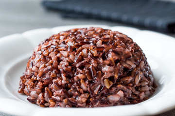 Cooked Black Rice in white Plate with Chopsticks.