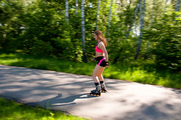 Roller skating woman in park rollerblading on inline skates.