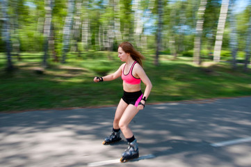 Roller skating woman in park rollerblading on inline skates. Beautiful woman learns to roller skate...