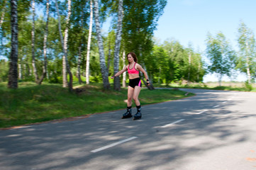 Roller skating woman in park rollerblading on inline skates. Beautiful woman learns to roller skate in the park. Rear view, front view, side view
