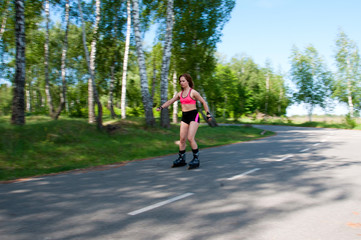 Fototapeta premium Roller skating woman in park rollerblading on inline skates. Beautiful woman learns to roller skate in the park. Rear view, front view, side view