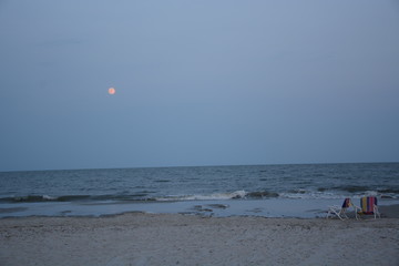 Full moon at dusk on the beach