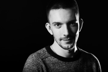 Portrait of a handsome young man. Black background.