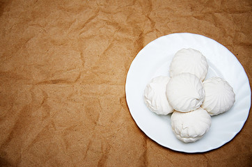 sweet marshmallow on white plate on paper background