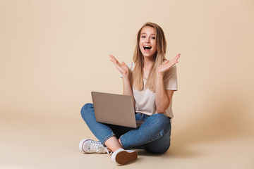 Portrait of a cheerful casual girl with laptop computer