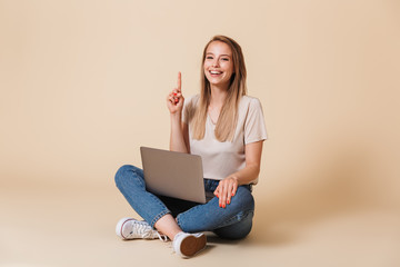 Portrait of a cheerful casual girl with laptop computer