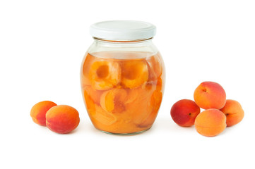 apricot compote in a glass jar and a bunch of ripe apricots on a white background. sweet and healthy dessert