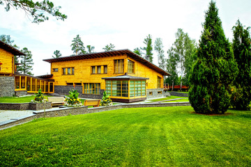 Facade of a beautiful wooden house with green garden