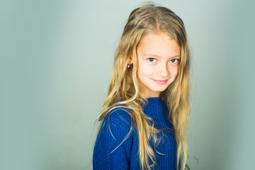 Fototapeta premium Stylish girl with pretty face on grey background. Beauty, kid fashion and healthy hair. Little girl with long hair. Fashion model, beauty, look. Hairdresser, skincare, casual style, denim.
