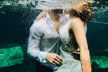 Beautiful Indian couple kisses under the water