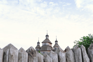 Obraz premium ancient fortification of a wooden palisade, of Cossack state guard army. Panoramic view from Khortytsia island on broad Dnipro summertime, wooden church and houses construction technology
