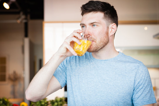 man drinking orange juice