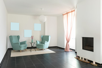 Detail of two turquoise armchairs in empty apartment