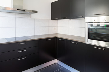 Dark kitchen with many doors and white tiles like parasolizzi