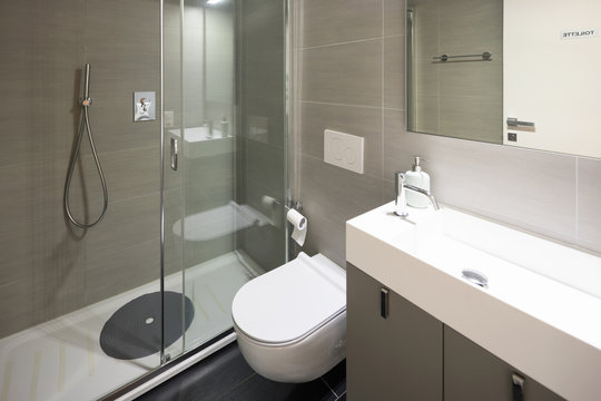 Modern bathroom with large brown tiles and large mirror