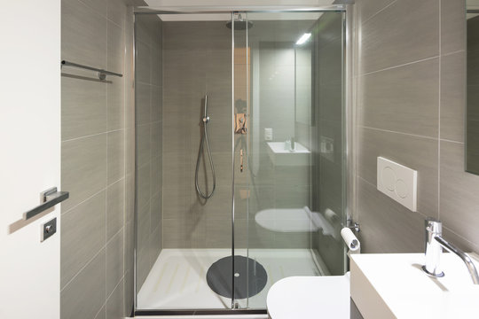 Modern bathroom with large brown tiles and large mirror