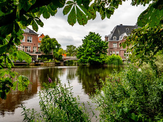 Obraz premium old mansion with little bridge, amsterdam on a river