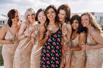 Hindu bride poses with her bridesmaids in the same dresses on the roof