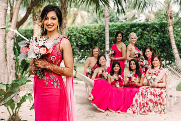 Indian bridesmaids admire beautiful bride posing together in the garden