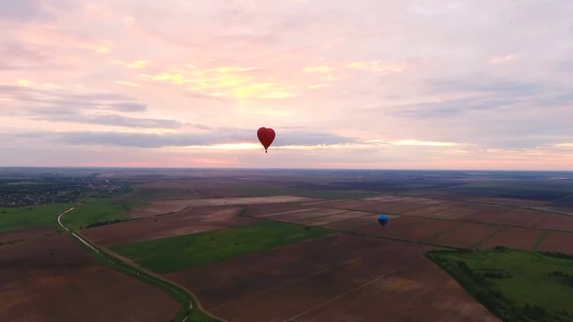 Hot air balloons in the sky over a field in the countryside.Aerial view:Hot air balloons in the sky over a field in the countryside the beautiful sky and sunset. 4K video,ultra HD.