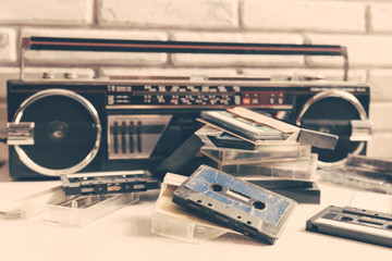 Obraz premium Vintage audio cassette on wooden background. Collection of a various retro audio tapes and tape recorder