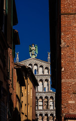 St Michael in Foro medieval church seen from Lucca historic center narrow lane