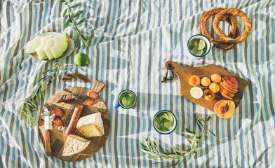 Photo sur Plexiglas Pique-nique Plat de pique-nique d& 39 été avec fruits, fromage, saucisses, bagels et limonade sur couverture rayée, vue de dessus