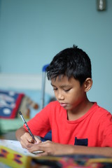 A boy writing something on the book