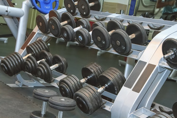 Heavy sports dumbbells in modern sports club