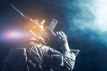Special forces soldier with rifle on dark background