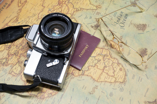 Holiday travel background with travel equipment on vintage world map.