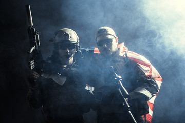 Fototapeta premium Soldier holding machine gun with national flag