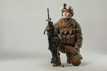 Soldier in camouflage holding rifle