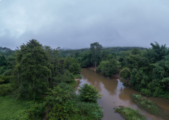 Beautiful natural scenery of river in Asia tropical green forest with mountains in background, aerial view drone shot